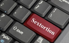 The word sextortion on a keyboard. GettyImages/payphoto
