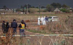 Members of the South African Police Service (SAPS) Forensic Pathology Services work on the crime scene where the body of a woman was discovered in Boksburg on September 17, 2026.