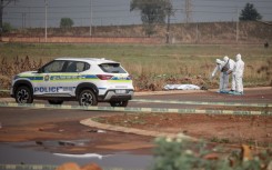 Members of the South African Police Service (SAPS) Forensic Pathology Services work on the crime scene where the body of a woman was discovered in Boksburg. AFP/Emmanuel Croset