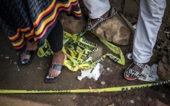 File: Residents stand behind police tape near a crime scene. AFP/Emmanuel Croset