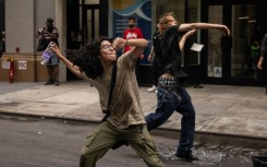 People throw ceramic plates and water bottles at police officers during riots sparked by Twitch streamer Kai Cenat, who announced a "giveaway" event in New York's Union Square on August 4, 2023
