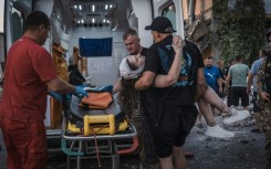 Rescuers carry a wounded woman following a Russian missiles strike in Pokrovsk, Donetsk region