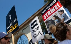 Members of the Writers Guild of America and the Screen Actors Guild walk a picket line outside of Paramount Pictures