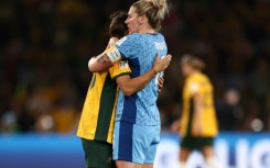 England defender Millie Bright (R) embraces Australia's forward Sam Kerr