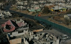 An aerial image shows destroyed homes and vehicles in the aftermath of the Maui wildfires in Lahaina, Hawaii on August 17, 2023