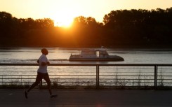 A man jogs along the docks at sunrise to avoid the heat, in Bordeaux, southwestern France