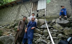 Survivor Rizwan Ullah (L, top), 15, sits outside the cable car tower after being rescued from a chairlift that hung for hours over a remote ravine after cables broke