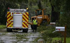 A first responder clears debris off the street in Perry, Florida after Hurricane Idalia slammed into the coast as a powerful Category 3 storm on August 30, 2023