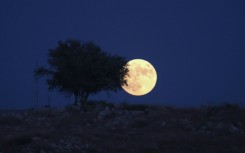 A picture taken from the Israeli city of Rosh Haain shows the 'Blue Moon' rising over the West Bank, on August 30, 2023