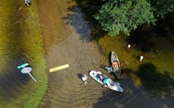 People prepare to kayak through the flooded streets of Crystal River, Florida, amid flooding caused by Hurricane Idalia