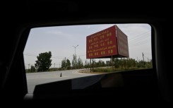 Political propaganda bearing the "Twelve Socialist Core Values" is seen on the road outside Yarkant in northwestern China's Xinjiang region