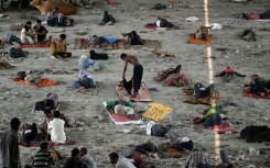 Homeless people take rest under a bridge to get respite from the heat on a hot summer afternoon in New Delhi