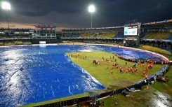 Rain pain: Ground staff cover the pitch after rain stopped play during the Asia Cup match between India and Pakistan 