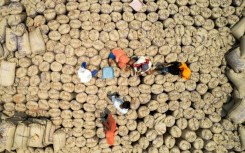Labourers seal gunny sacks of millet, the gluten-free grain which India has been championing and served at a G20 dinner, on the outskirts of Bengaluru earlier this year