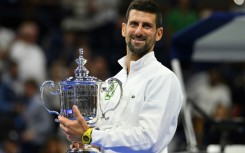 Novak Djokovic poses with the US Open trophy after winning it for the fourth time