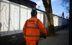 A construction worker walks outside a construction site for a section of Britain's HS2 high-speed railway project at London Euston train station 