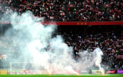 Smoked out: Flares are thrown onto the pitch as the game between Ajax and Feyenoord was abandoned
