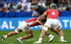 Scotland flanker Jamie Ritchie (C) is tackled by Tonga's lock Leva Fifita (R)