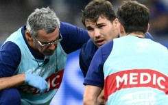 France captain Antoine Dupont (C) receives medical attention