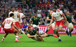 South Africa centre Andre Esterhuizen fights for the ball with Tonga lock Adam Coleman (R)