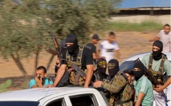 Palestinian militants move towards the border fence with Israel from Khan Yunis in the southern Gaza Strip