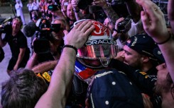 Team man: Max Verstappen celebrates with Red Bull team in the paddock in Doha 