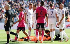Clermont goalkeeper Mory Diaw (C) lies on the ground after a firecracker exploded next to him during his side's Ligue 1 game at Montpellier