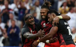 Fiji fly-half Vilimoni Botitu (right) celebrates scoring a try against England with captain Waisea Nayacalevu (centre) and flanker Levani Botia (left)
