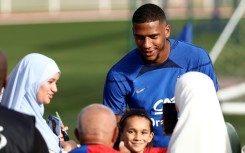 France defender Jean Clair Todibo (C) signs autographs before a training session ahead of Euro 2024 qualifiers 