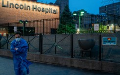 A member of the medical staff walks by a sign thanking medical workers at Lincoln Hospital in April 2020; While the initial public reaction to the pandemic was to honor health workers, they later found themselves on the frontlines of public frustration