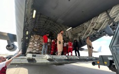 Volunteers from Qatar and Egypt's Red Crescent unload aid destined for the Gaza Strip at Egypt's El Arish airport