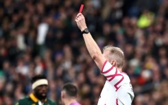 English referee Wayne Barnes shows a red card to New Zealand captain Sam Cane (not seen) during the Rugby World Cup Final against South Africa