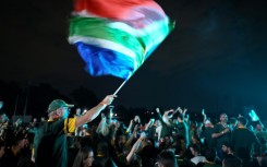 A Springboks supporter waves a South African flag at a Johannesburg sports club during the Rugby World Cup final.
