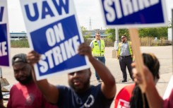 UAW members and workers at Mopar Parts Center Line, a Stellantis parts distribution center in Center Line, Michigan, hold signs after walking off their jobs on September 22, 2023 