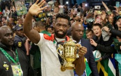 South Africa captain Siya Kolisi waves to supporters at Johannesburg airport while holding the Rugby World Cup trophy
