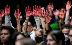 Protestors calling for a ceasefire in Gaza raise red-painted hands during a US Senate hearing in Washington, DC on October 31, 2023
