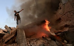 A Palestinian on the rubble of a collapsed building following an Israeli strike on Khan Yunis in south Gaza