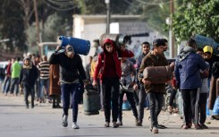 Palestinians in Rafah, the southern Gaza Strip, carry empty canisters to be filled with cooking gas from a shipment that entered as increased aid flows under the hostage release deal