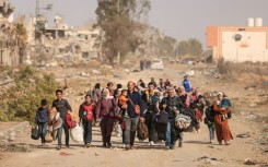 Palestinians fleeing the north walk along Salaheddine road in Zeitoun district on the outskirts of Gaza City