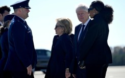 Former US Secretary of State Hillary Clinton, former US President Bill Clinton, and former US First Lady Michelle Obama are greeted upon arrival at Dobbins Air Reserve Base as they arrive to attend a tribute service for former US First Lady Rosalyn Carter