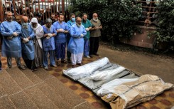 Physicians and other men are seem praying before bodies outside the morgue, in this file picture from November 14