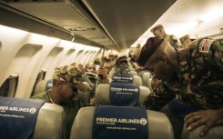 A first group of around 100 Kenyan soldiers from the East African Community regional force board a plane to leave the DRC