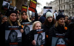 Demonstrators hold posters reading 'UN Women, your silence is loud' alongside pictures of Israeli women being held hostage in Gaza, during a rally in London on December 3, 2023 