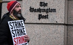 Employees of The Washington Post, joined by supporters, walk the picket line during a 24-hour strike outside of paper's headquarters