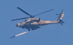 An Israeli air force attack helicopter fires a missile while flying in an area along the border with the Gaza Strip and southern Israel on December 12, 2023 