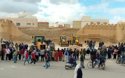 A crowd of onlookers gathers by the collapsed section of wall around the Old City of Kairouan, a UNESCO World Heritage Site and one of Tunisia's leading tourist attactions