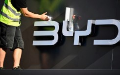 A worker cleans the company logo of Chinese carmaker BYD at their booth before the official launch of the International Motor Show (IAA) in the center of Munich, southern Germany, on September 4, 2023