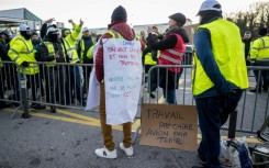 Striker wears a placard reading 'We want actions and not promises, our only mistake is to expect a CCT' during a picket line outside Geneva International Airport