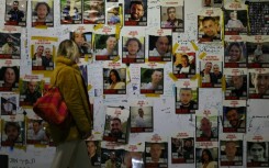 A woman looks at portraits of Israeli hostages on the sidelines of a rally calling for their release, in Tel Aviv