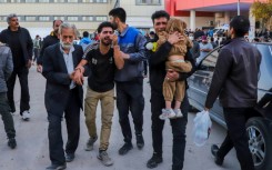 People injured in the explosions are helped outside a hospital in the southern Iranian city of Kerman on January 3, 2024